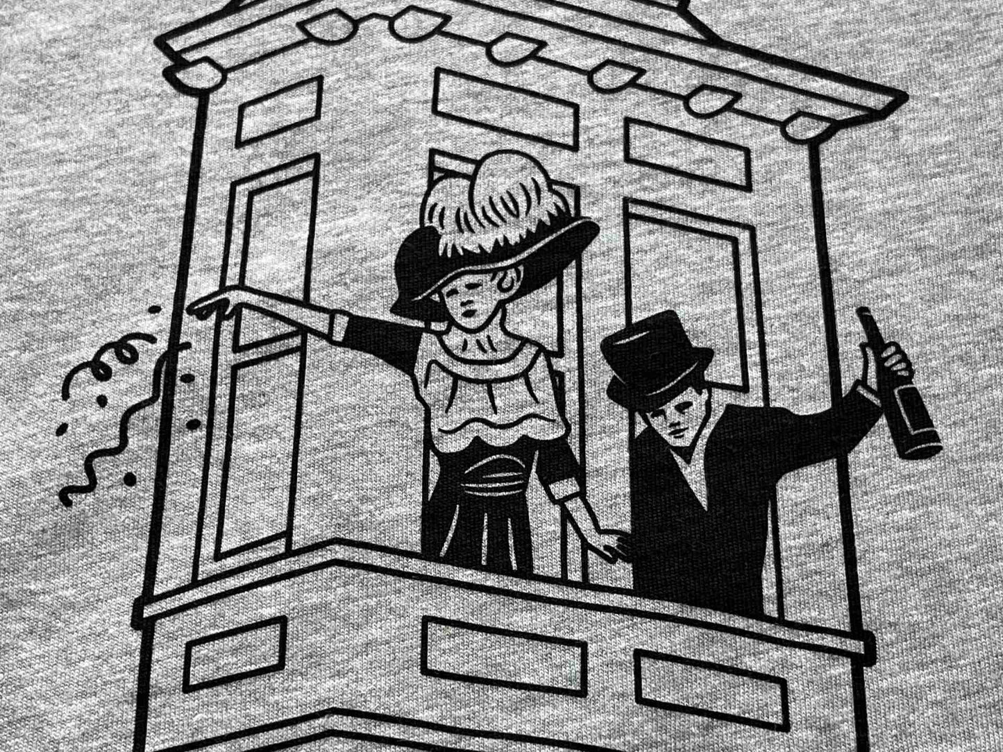 Detail image of people celebrating in the window of the Letson Building in Bisbee, Arizona